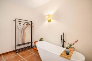 a white room with a white bath tub in a room at 赛家花园酒店SAI JIA Garden HOTEL in Dali Ancient Town