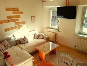 a living room with a couch and a flat screen tv at La Casa dei Nonni in Caralte