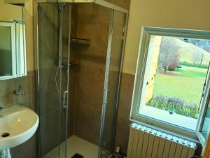 a bathroom with a shower and a sink and a window at La Casa dei Nonni in Caralte +15 photos