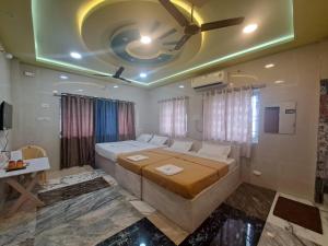 a bedroom with a large bed with a ceiling fan at Vijaya Lodge in Vadalūr