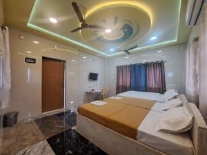 a bedroom with a large bed with a ceiling fan at Vijaya Lodge in Vadalūr +3 photos