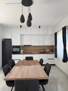 a kitchen with a wooden table and black chairs at Apartments Ars Vivendi in Trogir