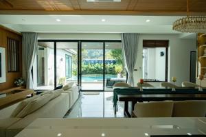 a living room with a couch and a table at Andara Ao Nang Pool Villa in Ao Nang Beach