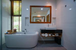 a bathroom with a tub and a sink and a mirror at Andara Ao Nang Pool Villa in Ao Nang Beach +18 photos