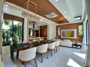a dining room with a long table and chairs at Andara Ao Nang Pool Villa in Ao Nang Beach