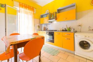 a kitchen with yellow cabinets and a table and chairs at Estrellas De Mar Casa in Giardini Naxos