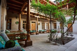 an outdoor patio with furniture and trees in a building at Salom Inn in Bukhara