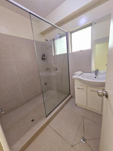 a bathroom with a shower and a sink at Aurora Mirage Apartments in Nadi
