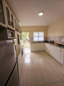 a large kitchen with white cabinets and white tile floors at Aurora Mirage Apartments in Nadi +19 photos