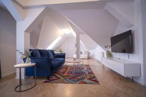 a living room with a blue couch and a tv at Apartmány Harmony Liptov - City Center & Private Wellness in Liptovský Mikuláš