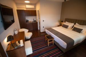 a hotel room with a large bed and a desk at Monastiri Mountain Escape in Konitsa