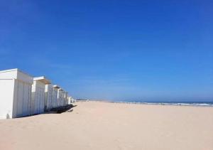 a beach with a row of buildings on the sand at L'escapade Sweet home - vue sur Mer et Dragon de Calais in Calais