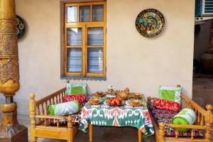a table with a plate of food on it at Salom Inn in Bukhara