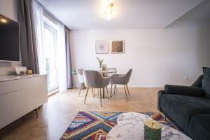 a living room with a table and a couch at Apartmány Harmony Liptov - City Center & Private Wellness in Liptovský Mikuláš