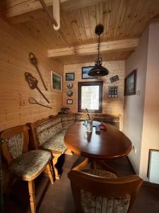 a dining room with a wooden table and chairs at Chata Mína in Smržovka