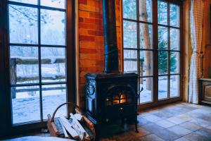 a wood stove in a room with windows at Iglasta chata in Warszkowo