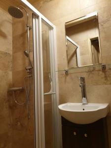 a bathroom with a sink and a shower with a mirror at Chata Mína in Smržovka +9 photos