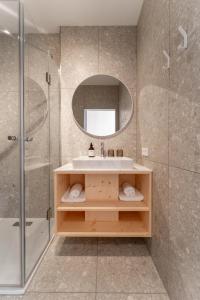 ein Badezimmer mit Waschbecken, Dusche und Spiegel in der Unterkunft Karlingerhaus Hotel Hostel Home in Königswiesen