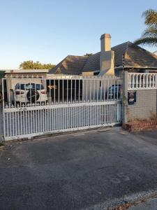 a white fence in front of a house at Ludiz Self Catering Accommodation in Avondale