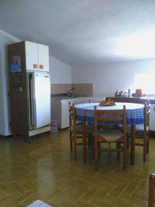 a kitchen with a table and chairs and a refrigerator at La casa di Titta in Di Natale