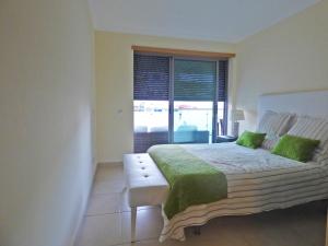 Un dormitorio con una cama grande y una ventana en Apartamento Olhos D'Água, en Albufeira