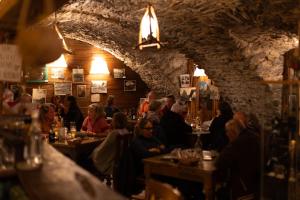 a group of people sitting at tables in a restaurant at Visaisa taverna & foresteria in Acceglio +34 photos