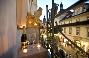a bottle of wine sitting on a table with wine glasses at Charles IV Apartments in Prague