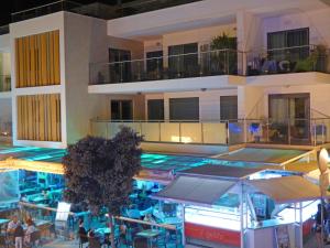a building with a swimming pool with people sitting at tables at Apartamento Olhos D'Água in Albufeira