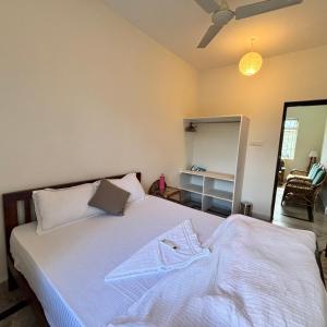 a bedroom with a white bed and a mirror at Nivrritii 3BHK Villa with hill and forest views in Canacona