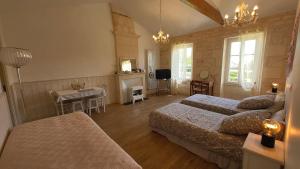 a bedroom with two beds and a table and a desk at ENTRE PIERRE ET BOIS in Saint-Savinien
