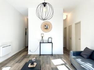 a living room with a couch and a table at LE WLÉRICK LUMINEUX - Spacieux - Hyper Centre in Mont-de-Marsan