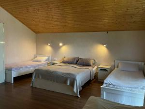a bedroom with two beds in a room with wooden ceilings at Orophile guest house in Gorists'ikhe