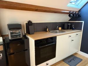 a small kitchen with a sink and a stove at Fuchsiahoeve in Blaricum