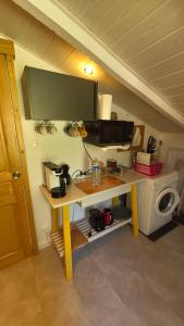 a room with a desk with a microwave and a table at ENTRE PIERRE ET BOIS in Saint-Savinien
