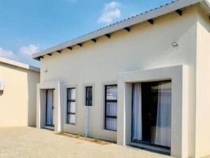 a white house with a garage at The Botik Hides in Mogwase +12 photos
