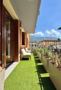 a balcony with green grass on a building at Valcamonica Apartments - Lake in Boario Terme