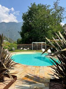 a swimming pool in a backyard with a gazebo at Valcamonica Apartments - Lake in Boario Terme