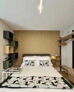 a bedroom with a bed with a black and white blanket at Valcamonica Apartments - Lake in Boario Terme +30 photos