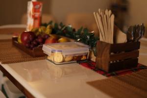 a table with a tray of apples and a box of pasta at Meis cottage Umpling in Shillong +5 photos