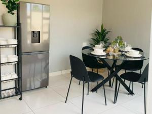 a dining room with a table and chairs and a refrigerator at The Botik Hides in Mogwase