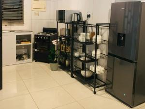 a kitchen with a refrigerator and shelves with dishes at The Botik Hides in Mogwase
