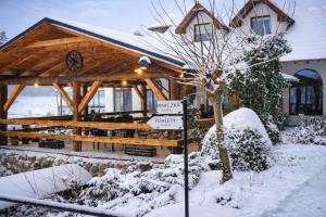 a wooden cabin with a sign in the snow at Malutkie Resort in Radomsko