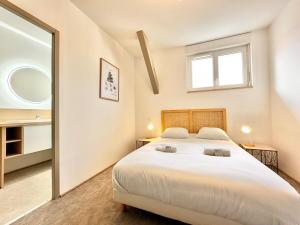 a bedroom with a large white bed and a mirror at Le Ronsard - Élégance - Central in Mont-de-Marsan