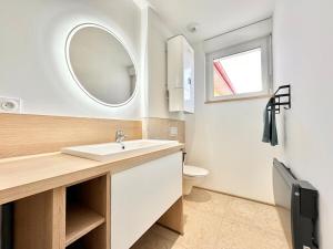 a bathroom with a sink and a toilet and a mirror at Le Ronsard - Élégance - Central in Mont-de-Marsan