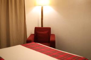 a room with a bed and a chair and a lamp at Meis cottage Umpling in Shillong