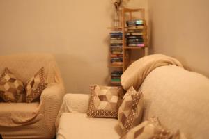 a living room with a couch and a book shelf at Meis cottage Umpling in Shillong