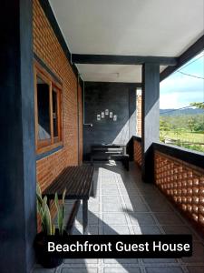a balcony with a bench and a guest house at Beachfront Guest House Pacitan in Tamperan