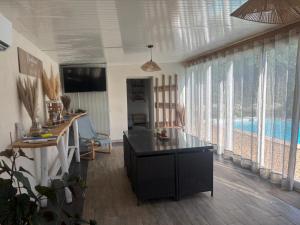 a living room with a table and some windows at Échappée Mistral - Jacuzzi Privé & Brasero in Eyragues