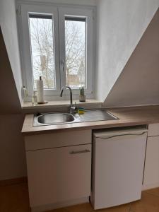 a kitchen with a sink and a window at Ferienwohnung mit Küche und Bad in Hollenbach