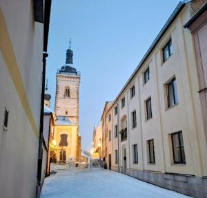 a building with a clock tower in the middle of a street at Apartmány Stříbro in Stříbro